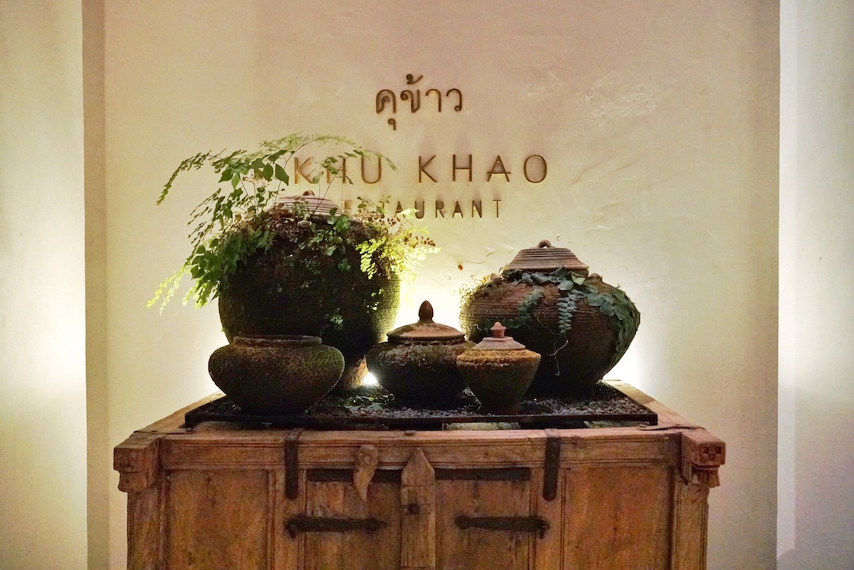Khu Khao Restaurant 入口招牌以古米缸做為裝飾搭配盆栽點綴，讓人感受一種閑逸自然的風格。